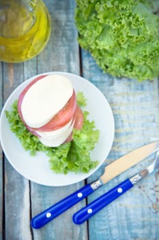 salad with mozzarella,tomatoes,dark basil on wooden retro background