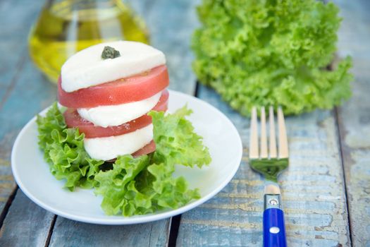 salad with mozzarella,tomatoes,dark basil on wooden retro background