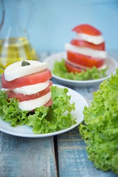 salad with mozzarella,tomatoes,dark basil on wooden retro background