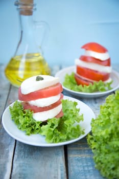 salad with mozzarella,tomatoes,dark basil on wooden retro background