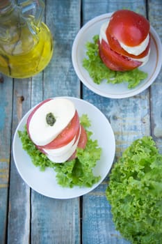 salad with mozzarella,tomatoes,dark basil on wooden retro background