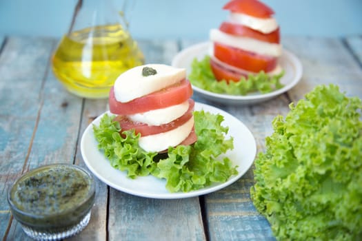 salad with mozzarella,tomatoes,dark basil on wooden retro background