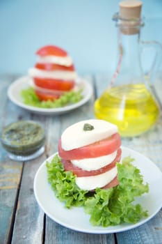 salad with mozzarella,tomatoes,dark basil on wooden retro background