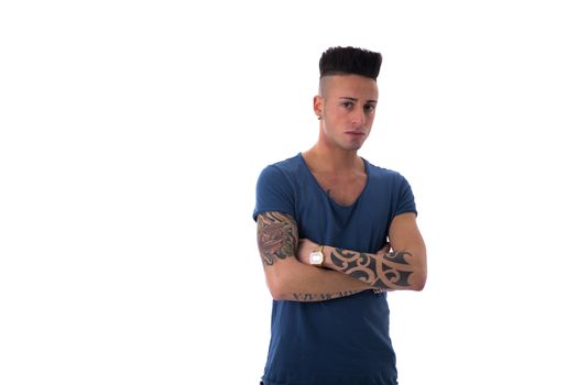 Portrait of trendy young man in blue t-shirt and jeans with arms crossed on chest, isolated on white