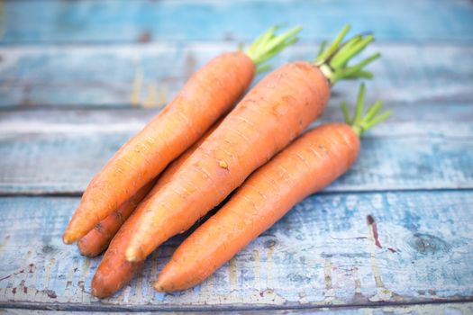 stack of fresh, to the ripe carrot on a wooden background