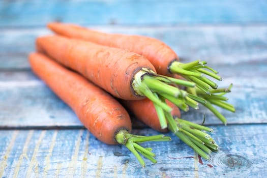 stack of fresh, to the ripe carrot on a wooden background