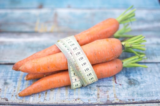 stack of fresh, to the ripe carrot on a wooden background