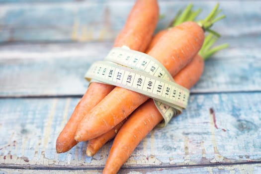 stack of fresh, to the ripe carrot on a wooden background