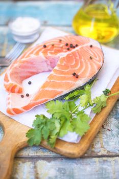 piece of raw red fish with parsley, pepper and olive oil