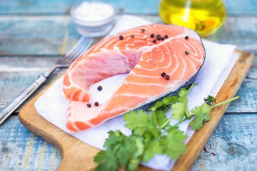 piece of raw red fish with parsley, pepper and olive oil