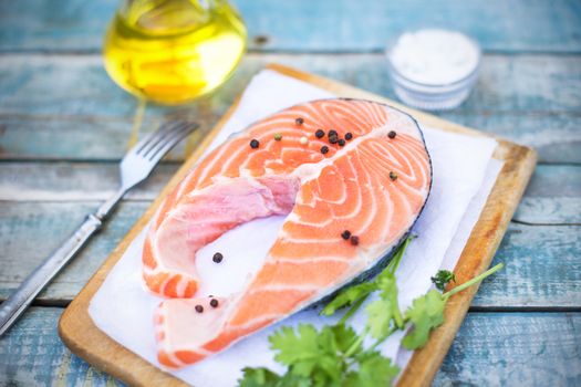 piece of raw red fish with parsley, pepper and olive oil