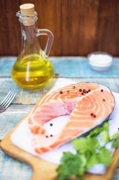 piece of raw red fish with parsley, pepper and olive oil