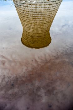 Cooling tower of the cogeneration plant reflected in water.