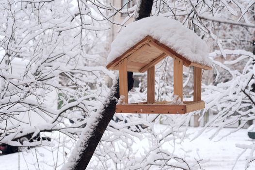 wooden bird table topped with fresh snow