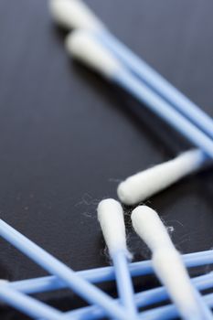 Random pile of blue plastic cotton ear buds for cleaning wax out of the ear in a health and hygiene concept