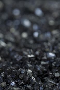 Background texture of an asphalt or tarmac road surface showing the tiny stones in the gravel with shallow dof