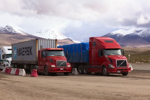 PASO CHUNGARA-TAMBO QUEMADO, CHILE-BOLIVIA - JANUARY 21, 2015: Trucks standing in line at the border crossing between Chile and Bolivia at Chungara and Tambo Quemado on the way between La Paz and Arica on January 21, 2015