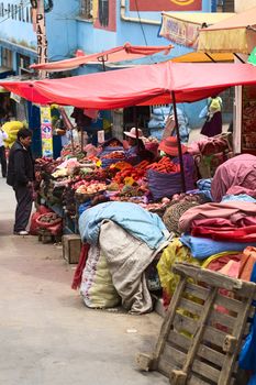LA PAZ, BOLIVIA - NOVEMBER 10, 2014: Unidentified street venders selling vegetables on the roadside on Zoilo Flores street in the city center on November 10, 2014 in La Paz, Bolivia. In this area there are many fruit and vegetable stalls along the streets.