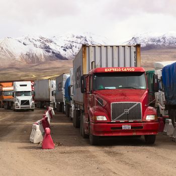 PASO CHUNGARA-TAMBO QUEMADO, CHILE-BOLIVIA - JANUARY 21, 2015: Trucks standing in line at the border crossing between Chile and Bolivia at Chungara and Tambo Quemado on the way between La Paz and Arica on January 21, 2015 (Selective Focus, Focus on the first truck)