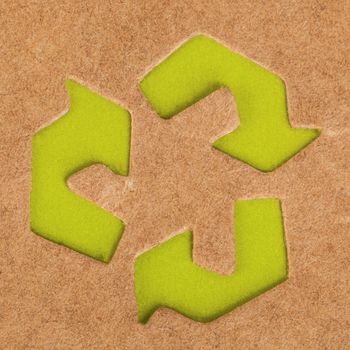 green recycle symbol on cardboard box background