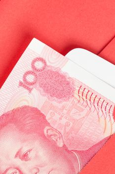 Chinese or 100 Yuan banknotes money in red envelope, as chinese new year background