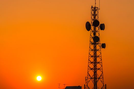 Telecommunication tower structure with sunset sky in silhouette background