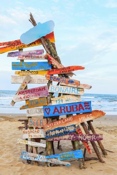 travel traffic sign stick on timber or bonfire tent at sand beach