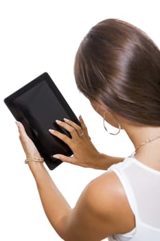 Attractive young business woman standing chatting on a mobile while simultaneously reading a tablet computer with a smile, isolated on white