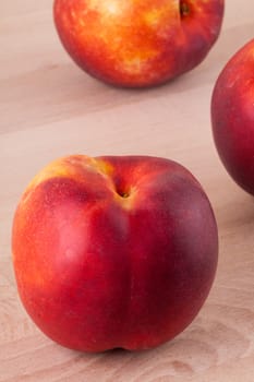 Three tasty fresh ripe juicy nectarines on white painted wooden boards for a healthy snack and diet