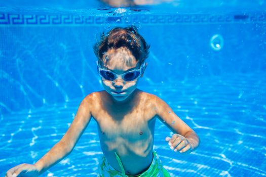 Underwater happy little boy in swimming pool