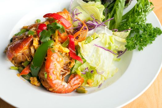 Thai jumbo shrimp salad on a round white plate. Shallow depth of field.