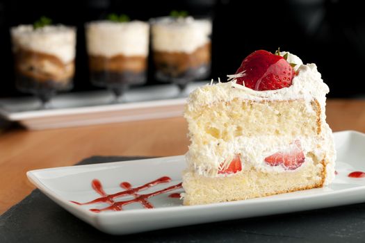 Slice of strawberry shortcake with white chocolate shavings.