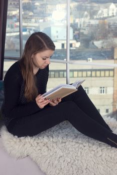 Woman studying at home and looking through the window