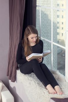 Woman studying at home and looking through the window