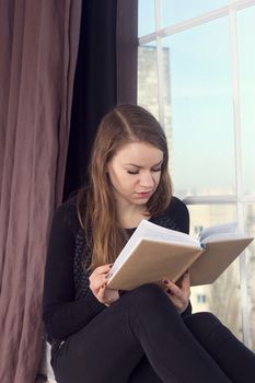 Woman studying at home and looking through the window