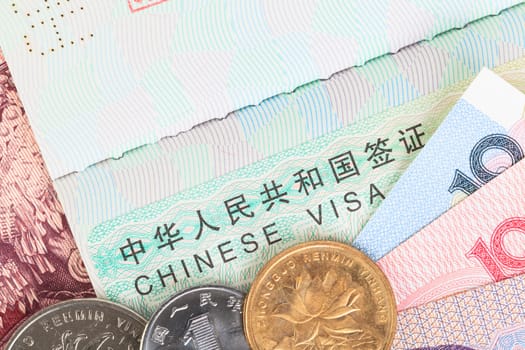 Chinese or Yuan banknotes money and coins from China's currency with visa for travel concept, close up view as background