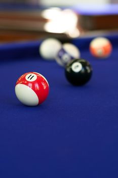 Billiard balls on a purple fabric pool table. Shallow depth of field with sharpest focus on the 11 ball.