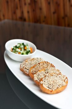 Thai or Asian style shrimp sesame toasts with garnish and cucumber salad.