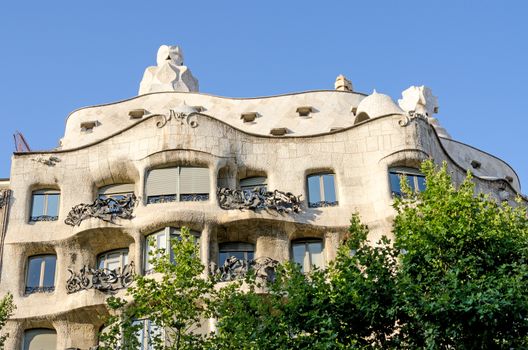 Famous Barcelona landmark - Antonio Gaudi's work Casa Milo (or La Pedrera) building by bright sunny day