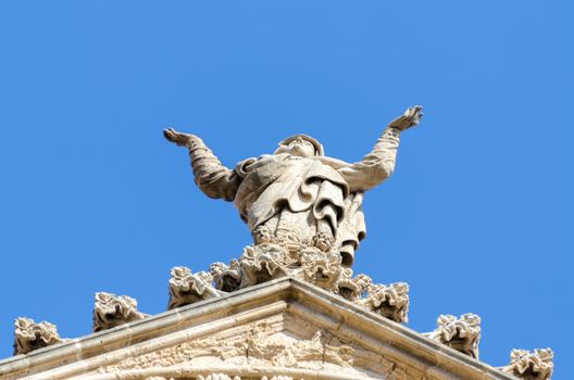 Details of roof church facade in Spain. Praying woman statue.