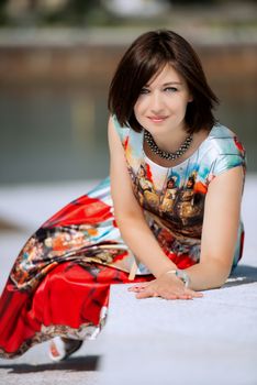 Brunette girl model in dress posing on exterior set