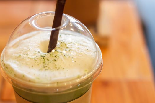 Iced green tea latte with milk foam, stock photo