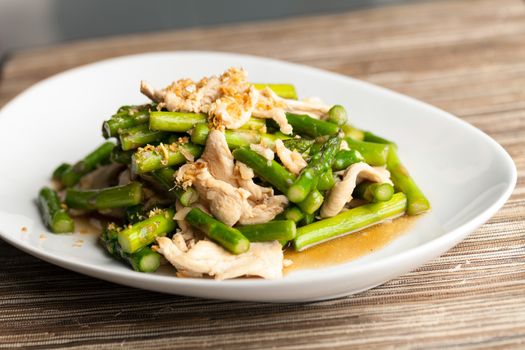 Freshly prepared Asian style chicken and asparagus stir fry with garlic.