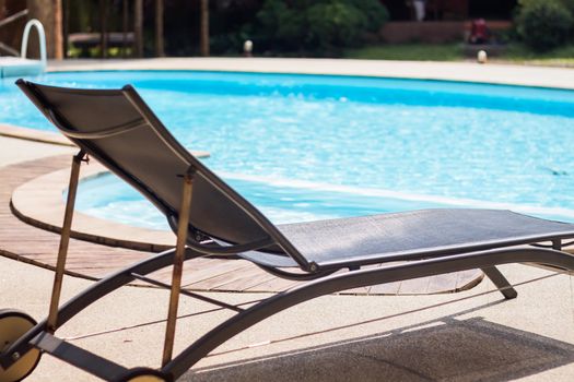 Swimming pool with beach chairs, stock photo