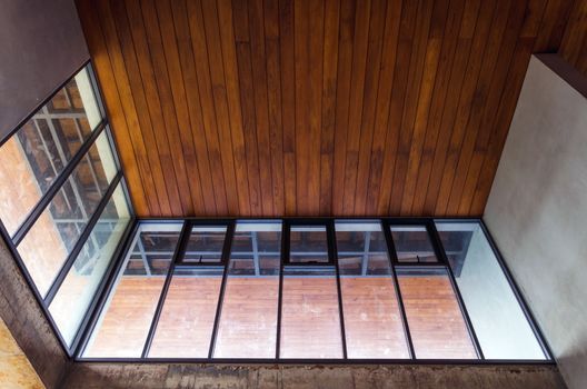 Aluminum window with wooden ceiling in house under construction