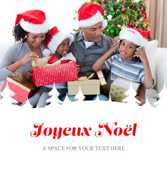 Happy family playing with Christmas presents against joyeux noel