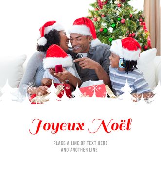 Happy family having fun with Christmas presents against joyeux noel