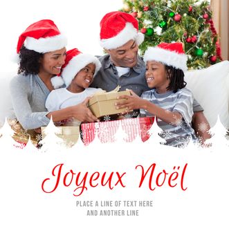 Family holding Christmas gifts against joyeux noel
