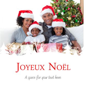 Family holding Christmas presents against joyeux noel