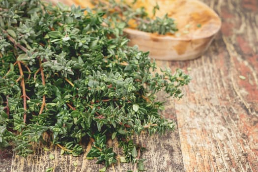 Bunch of fresh Thyme on the rustic wooden table. A macro photograph with  shallow depth of field